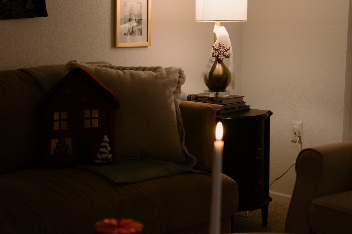 A lit candle glowing in a cozy room