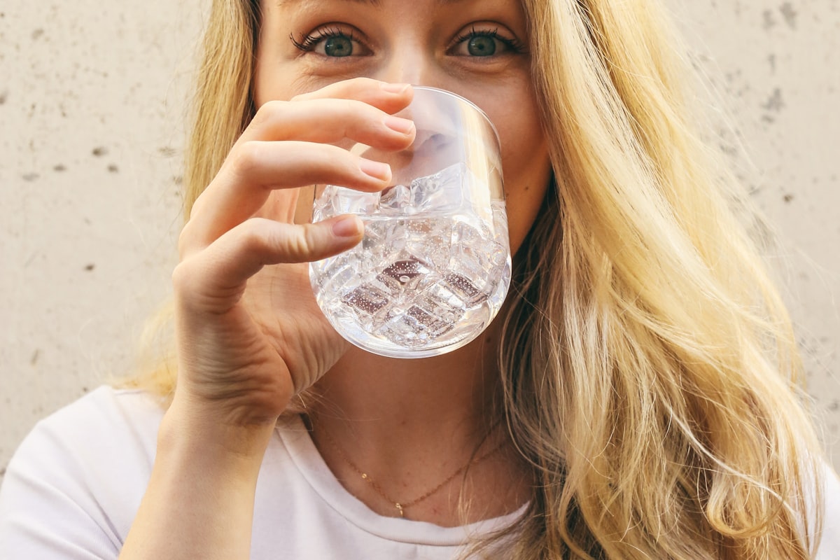 A person drinking a glass of water