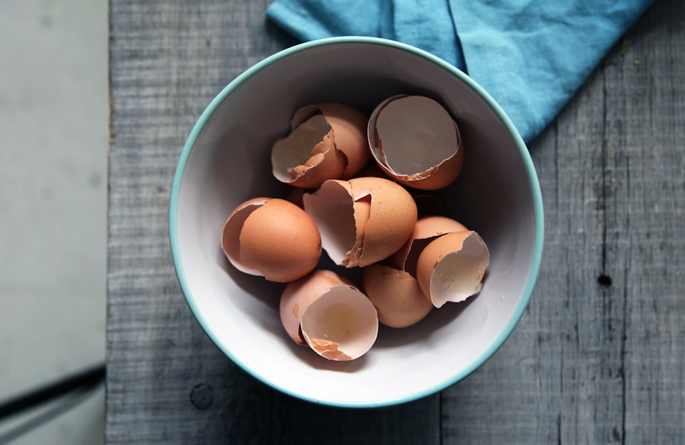Peeled boiled eggs and eggshells in a bowl