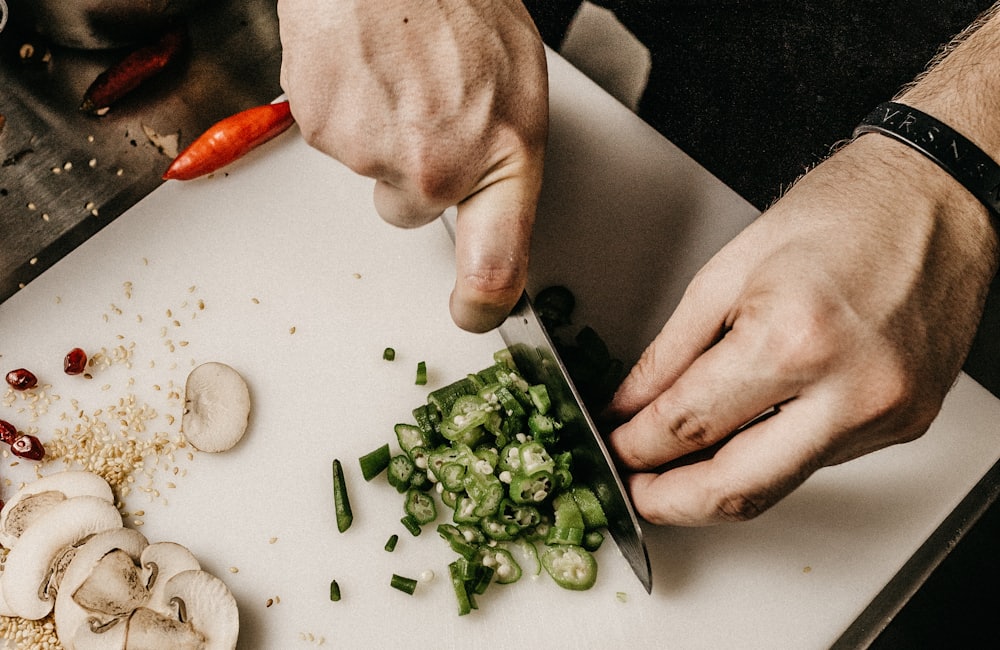 A sharp chef's knife slicing vegetables on a board