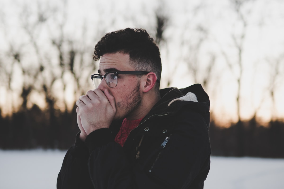 Man raising his hands to his mouth to whistle loudly outdoors
