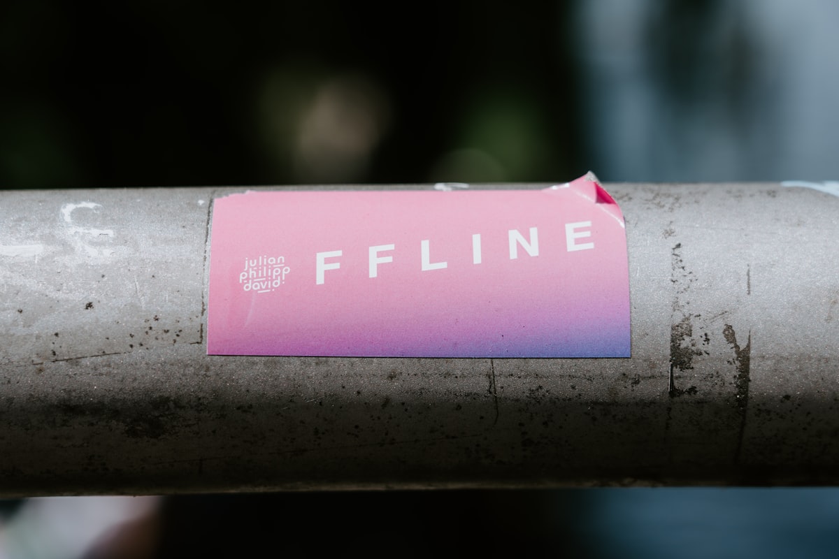 A partly peeled sticker on a metal surface